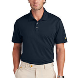 Man wearing a navy 2 button polo shirt with khaki pants