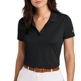 Woman wearing a black buttonless polo shirt paired with white pants and a brown belt