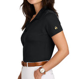 Woman facing the side wearing a black polo shirt with the Brooks Brothers logo on the left sleeve